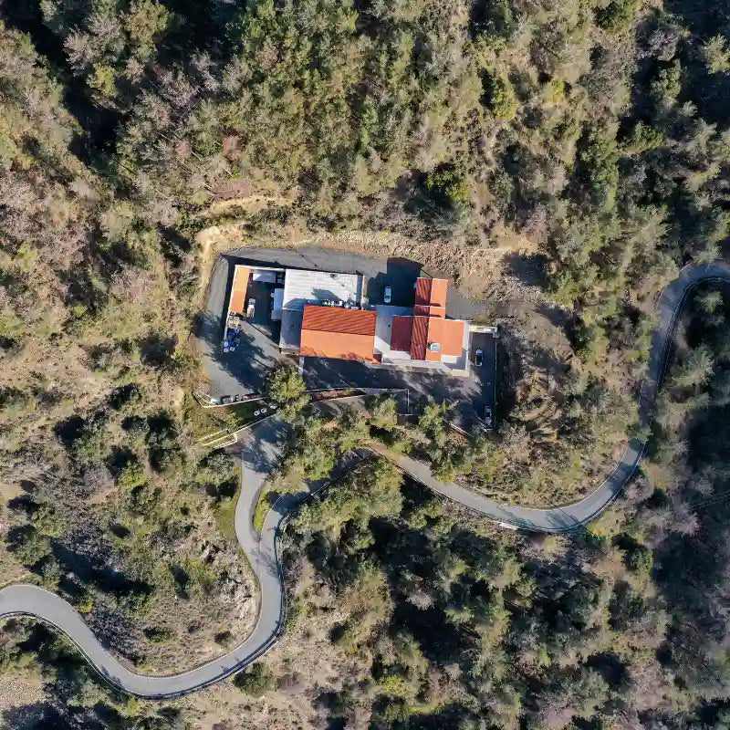Aerial view of a house surrounded by dense forest